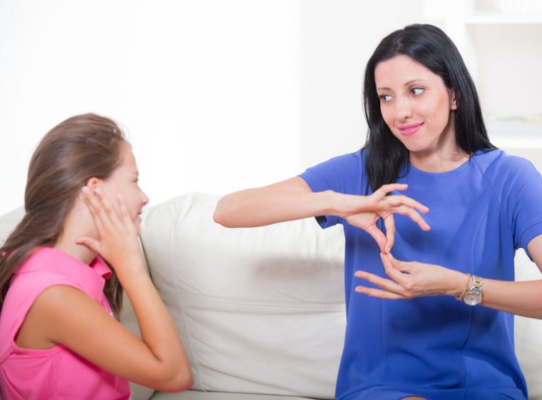 Smiling deaf girl learning sign language